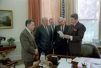 Photographie en couleurs d'hommes d'états en pleine discussion et réunis dans un bureau