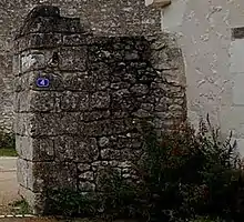 Photographies en couleurs d'un pilier portant un numéro d'adresse et d'une partie de mur faits de pierre.