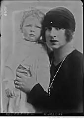 Photographie en noir et blanc d'une jeune femme brune avec un enfant blond.