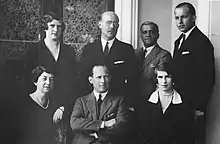 Photographie en noir et blanc d'un groupe de sept hommes et femmes.
