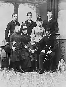 Photographie noir et blanc d'une famille de huit personnes accompagnée d'un chien.