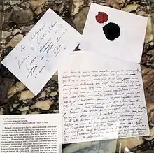 Photographie de courriers manuscrits et d'une enveloppe avec un sceau de cire.
