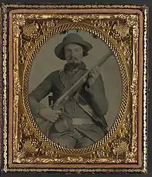 Soldat Elijah S. Leach, de la compagnie B du 31st Virginia Infantry,en uniforme, avec un mousquet, sa boite d'amorces et sa musette.