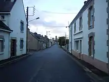 Photographie en couleurs d'une rue bordée de maisons.