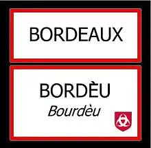 Photographie d'un double panneau ou est inscrit Bordeaux en français et en gascon.