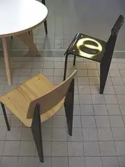Photographie en couleurs montrant deux chaise et une partie d’une table vue du dessus.