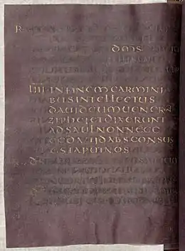 Parchemin manuscrit de couleur pourpre et aux lettres dorées.