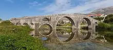 Photographie du pont Arslanagić, se reflétant sur la Trebišnjica.