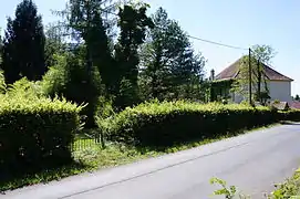 Un parc derrière une haie non loin de l'ancien bâtiment des machines, transformé en maison.