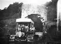 Bulldozer déversant du schiste dans le puits entouré d'un mur.