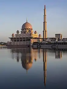 Un grand bâtiment ouvragé surmonté d'un dôme avec à côté une fine tour.