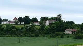Maisons et une église qui dominent la route : voilà Puy-de-Fourches.