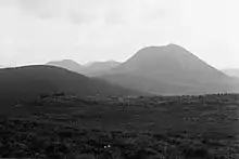 Photographie noir et blanc montrant un premier puy au premier plan et d'autres à l'arrière plan.