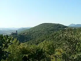 Puy de la Bannière vu depuis Beauvaleix (hameau de la commune d'Enval). Sur un des contreforts du puy, à gauche : le château de Tournoël. En arrière-plan à droite : le puy de Dôme.