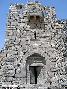tour en pierre, porte entrouverte sous une arche