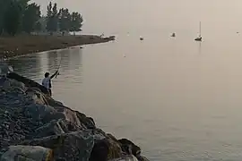 Plage, empierrement du quai, pêcheuse