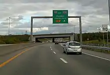 Une voie rapide avec une supersignalisation et un panneau de limite de vitesse.