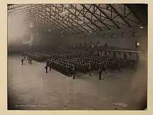 Photo en noir et blanc de militaires en formation à l'intérieur d'un bâtiment