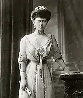 Photographie en noir et blanc d'une femme portant diadème et bijoux.