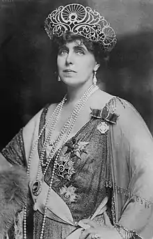 Photo d'une femme portant un grand diadème et de multiples décorations.
