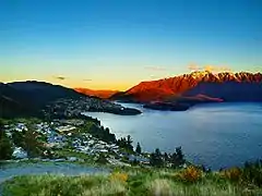 La ville est à gauche, au bord du lac, et ils sont entourés par des montagnes (les Alpes du Sud).