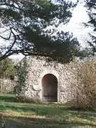 Vue du pignon d'une chapelle percé d'une porte romane.