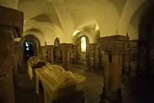 Photographie d'une crypte-halle avec des gisants au centre