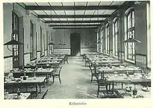 Photographie du réfectoire du lycée : des tables alignées et des chaises.