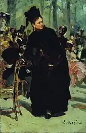 Portrait d'une femme habillée en noir, debout.