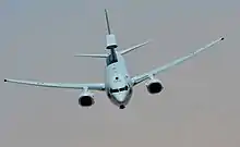 Photographie d'un avion bi-moteur en vol, vu de face.