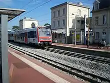 Un élément Z 8800 de la ligne C du RER stationné devant le bâtiment voyageurs.