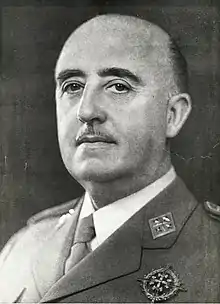 Photographie en noir et blanc d'un homme à moustache, cheveux grisonnants, calvitie prononcée, vêtu d'un uniforme militaire.