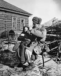 Un soldat tenant un enfant dont la mère a été tuée (octobre 1943).
