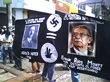 Manifestation étudiante de 2006 à la ville de Guatemala. La photo montre des étudiants portant une banderole comparant Efraín Ríos Montt à Adolf Hitler.