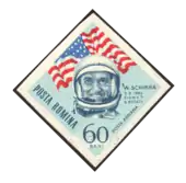 Scan d'un timbre roumain avec la tête casquée de Schirra devant un drapeau des États-Unis.