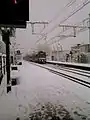 Un train en provenance de Paris arrive voie 1 sous la neige.