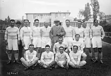 Photographie en noir et blanc d'une équipe de rugby sur un terrain posant pour une photographie de groupe.