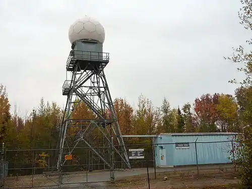 Radar de Villeroy à 75 km au sud-ouest de la ville de Québec (un WSR-98E) : tour et radôme à gauche, transmetteur et récepteur dans le bâtiment à droite.