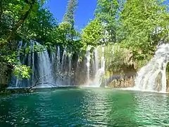 Un arc-en-ciel dans des chutes dans les lacs supérieurs de Plitvice.