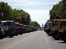 Camions du Dakar 2009, stationnés dans l'avenue. Au fond : le Monumento de los españoles.