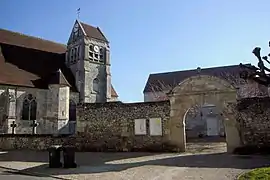 Le portail inscrit M.H. de l'ancien presbytère, et la façade sud de l'église.