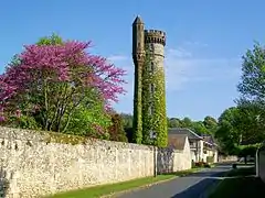 La tour haute de 30 m ; derrière, l'orangerie puis l'ancienne écurie du château sont visibles.