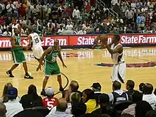 Le no 20 des Celtics de Boston jouant en vert, Ray Allen, défend sur Josh Smith (le joueur d'Atlanta qui a la balle dans les mains) pendant un match de basket-ball sur un parquet de NBA.