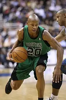 Joueur portant le maillot vert numéro 20 de Boston en dribble