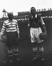 Les capitaines des deux équipes posent pour une photo, chacun portant un ballon dans une main.