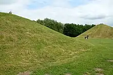 Deux buttes, reconstitution de deux tumulus avec au milieu une sculpture