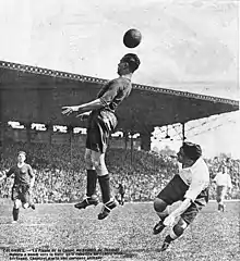 Dans un match de football, un joueur saute et fait un contrôle de la tête.