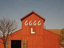 Vue d'une grange de couleur ocre avec les chiffres 6666 peints en blanc