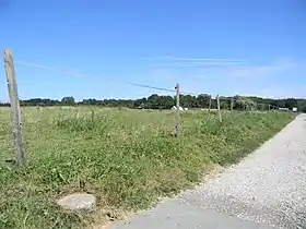 Terrain de la redoute du hameau de la roche. Au premier plan, une borne de propriété militaire.