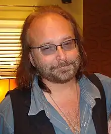 Photo d'un homme barbu aux cheveux longs portant des lunettes